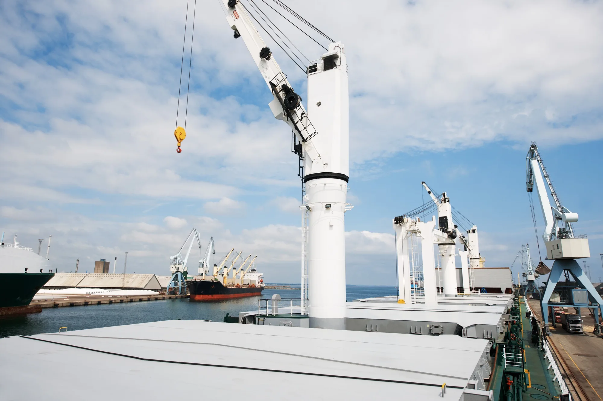 The shipyard never sleeps. A photo of a harbor with anchored ships with cranes.